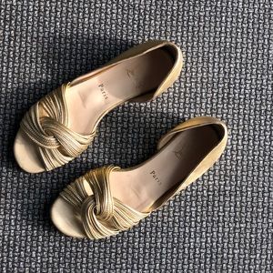 Christian Louboutin golden leather flat sandals with knot detail.